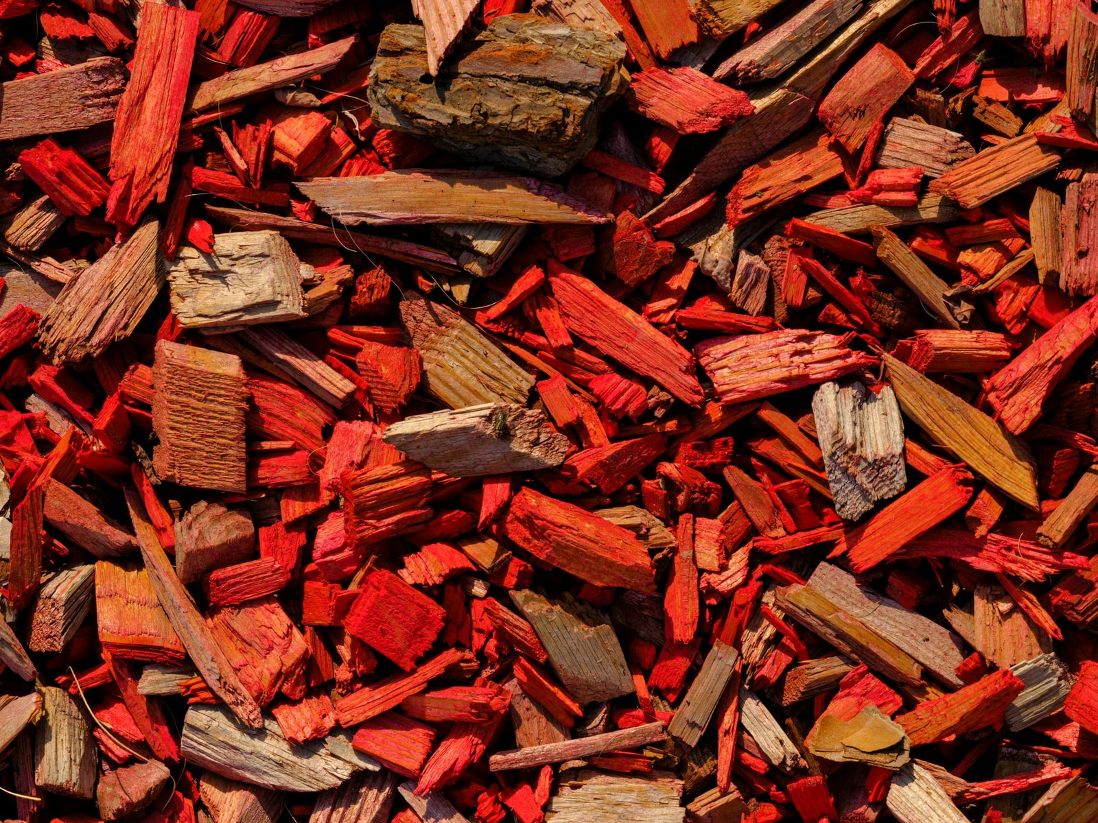 A pile of bright dyed-red wood mulch